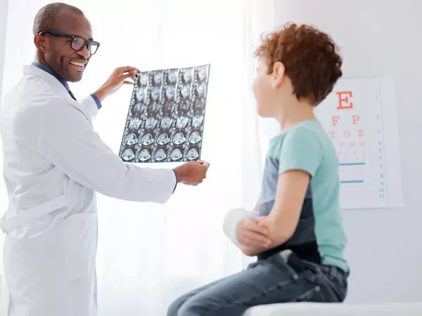 Happy male doctor showing brain imaging to boy