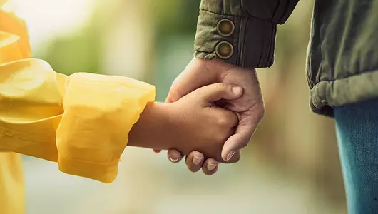 closeup of a man holding young child's hand