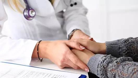 female doctor holding the hand of a patient