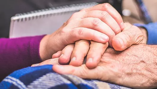 nurse holding a man's hand