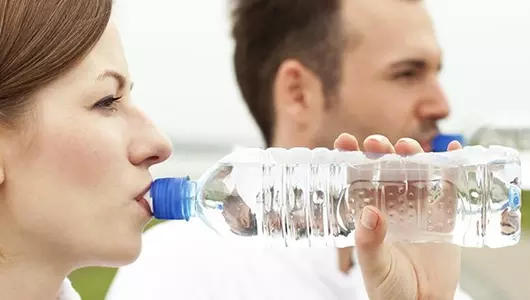 Man and woman drinking bottled water