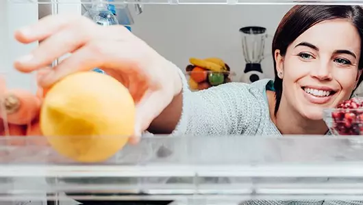 stock your kitchen for success-woman stocking fridge