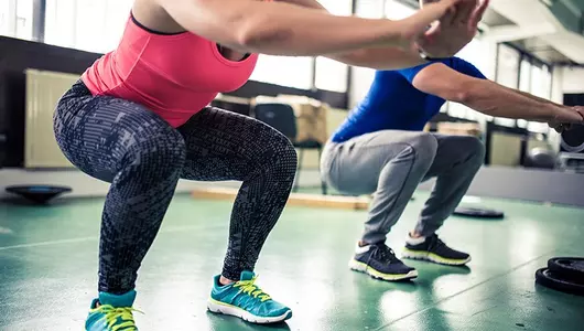 man and woman doing squats