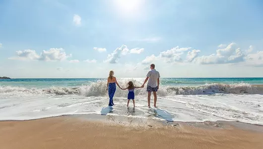 family standing on the beach