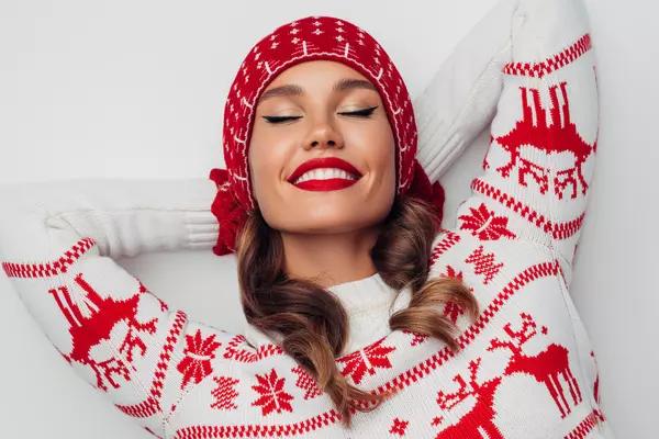 Woman in winter sweater and hat, relaxed with eyes closed